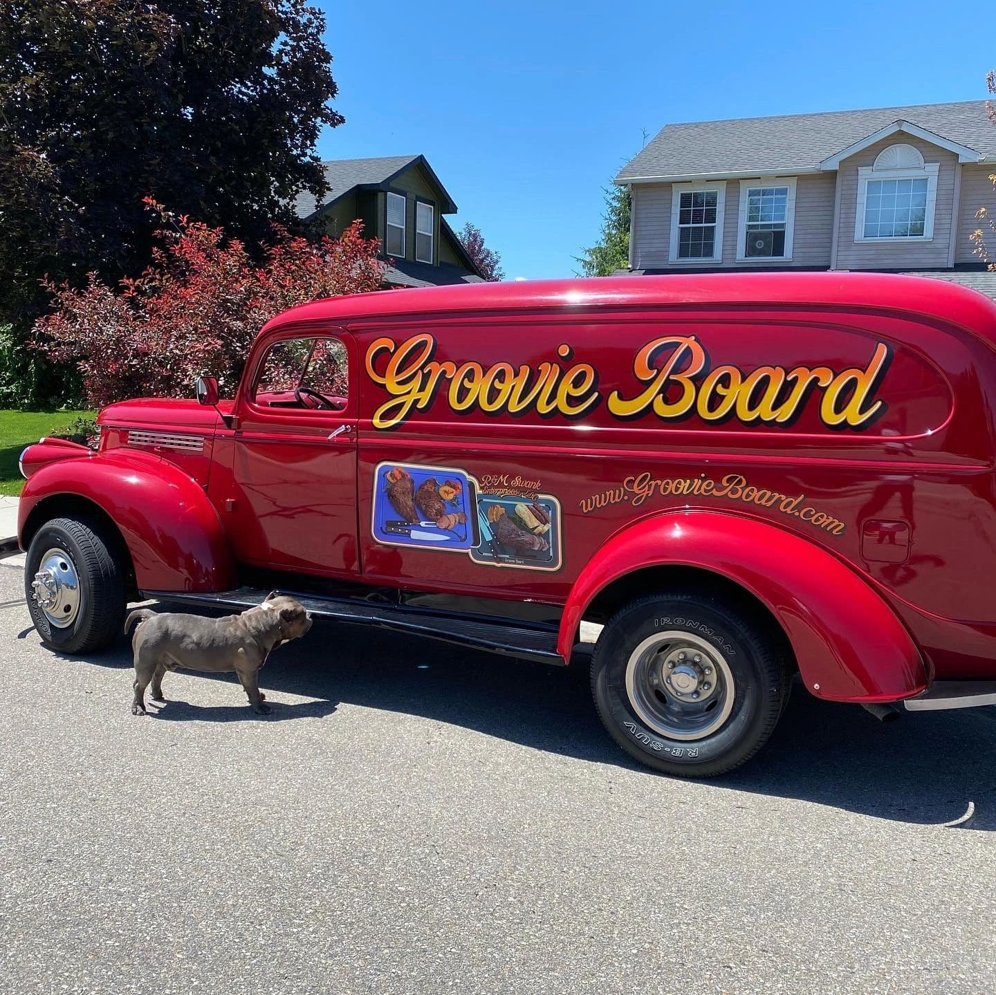 Red vintage Groovie Board car with gold lettering and a dog beside it