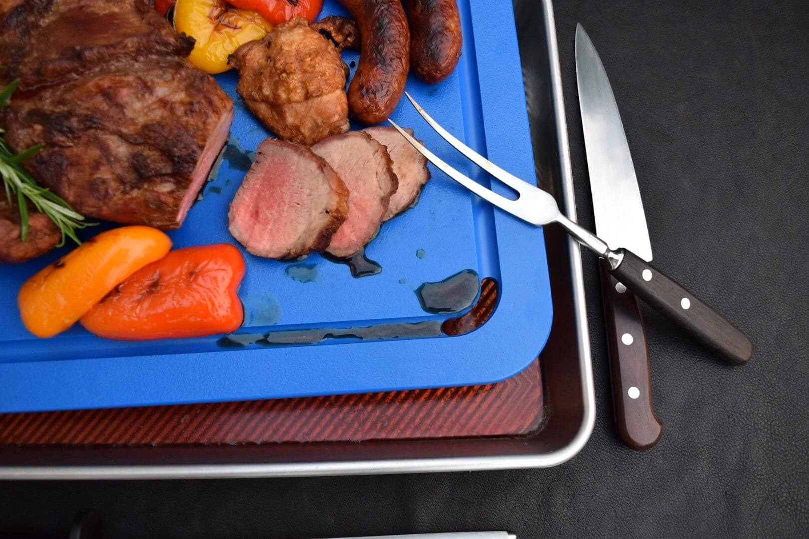 Blue Groovie Board directing carving juices into its fitted pan